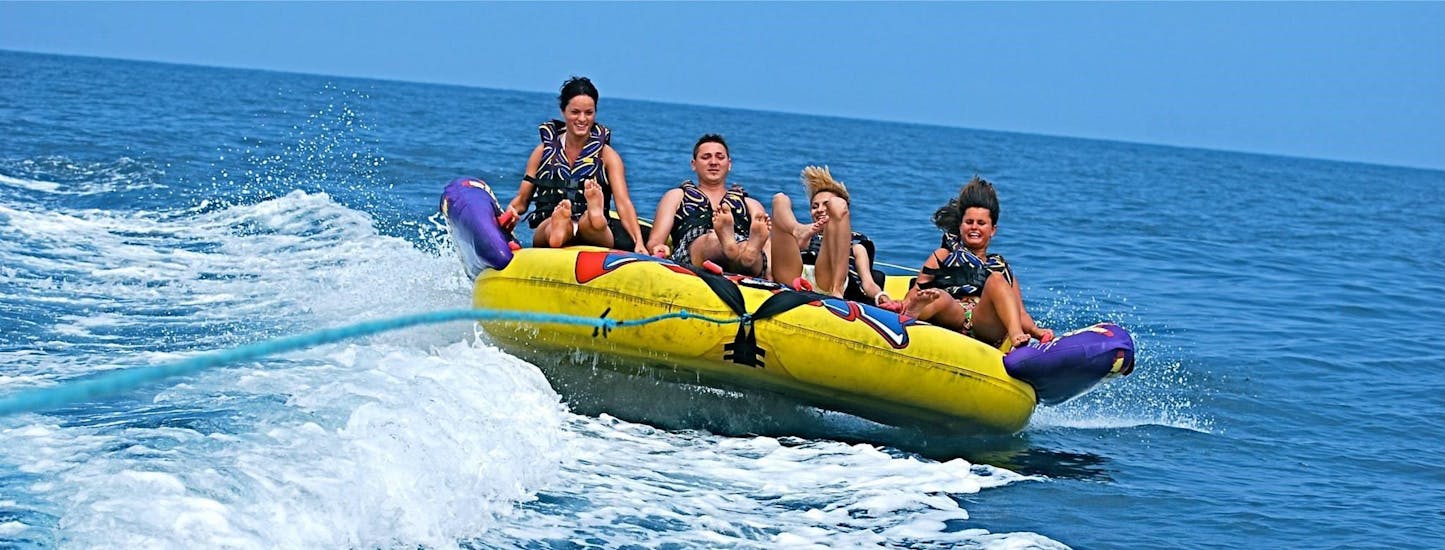 Eine Gruppe von Freunden geht mit Sun & Fun Watersports Malta auf eine Fahrt mit dem Crazy Sofa in St. George's Bay.