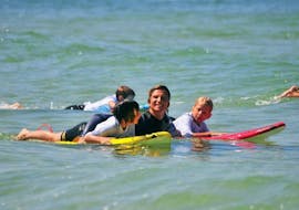 Ein Kind surft während seines Surfkurses am Mimizan Beach mit der Mimizan Surf Academy.