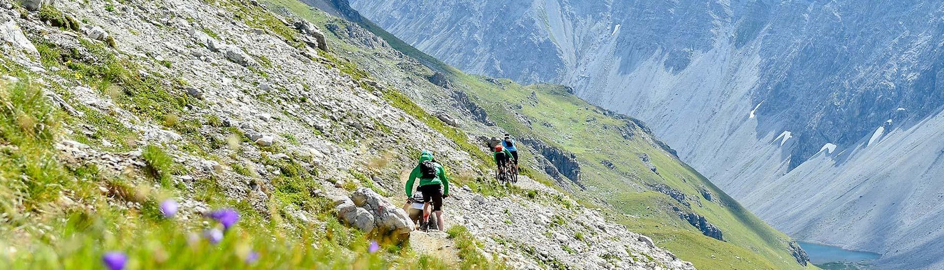 Radfahrer fahren beim Privaten Mountainbike Guiding in Lenzerheide mit Epic Lenzerheide durch die Berge.