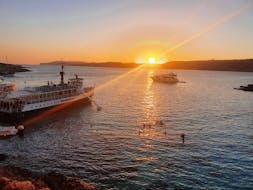 Un grupo de personas observa la puesta de sol en el horizonte, durante un paseo en barco a la Laguna Azul al amanecer, con Hornblower Cruises.