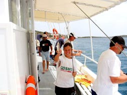 Un niño pescando en un viaje en barco privado desde Agios Nikolaos con Nostros Cruises.