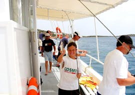 Un niño pescando en un viaje en barco privado desde Agios Nikolaos con Nostros Cruises.