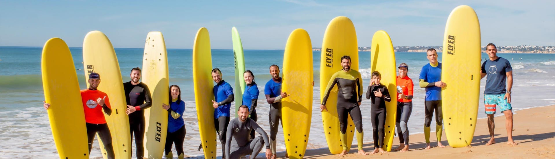 Eine Gruppe aufstrebender Surfer hat sich am Strand versammelt, um an einem mehrtägigen Surfkurs für Kinder und Erwachsene - alle Niveaus mit Surf Albufeira teilzunehmen.