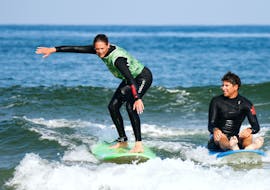 A girl is learning how to surf during her Surf Lessons (from 6 y.) on Moliets Beach with Moliets Surf School.