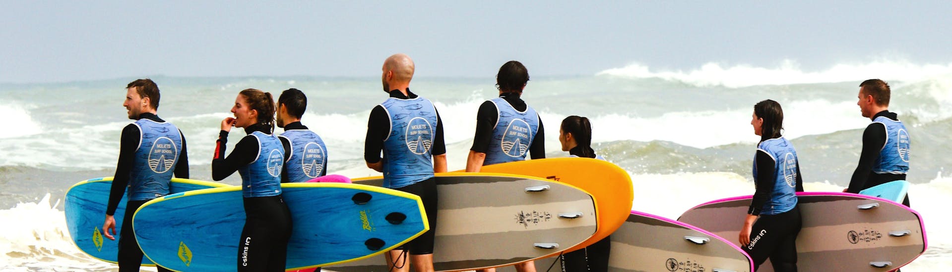 Unos niños en la playa de Moliets durante su clase de surf con Moliets Surf School.