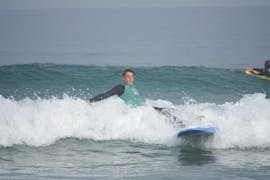 Un petit garçon essaie d'apprendre le surf.