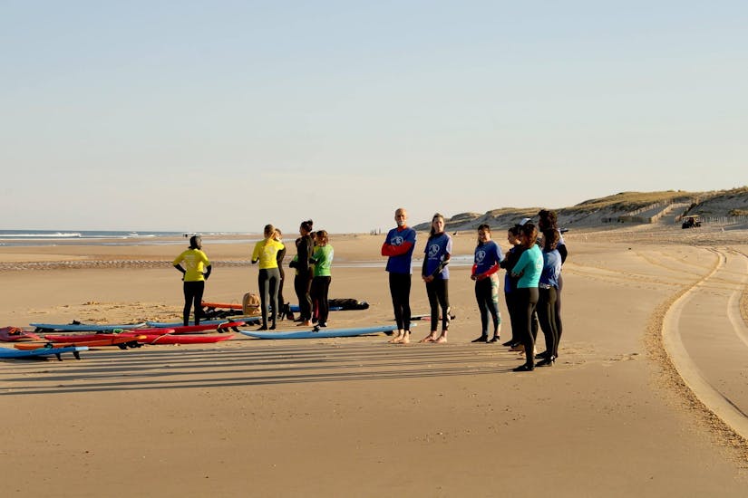 Groupe d'amis sur la plage de Lacanau prenant des cours de surf avec HCL Lacanau.