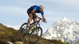 Zu sehen ist ein Radfahrer, der mit einem Leihfahrrad des Fahrradverleihs Skischule & Bikeverleih AGE Ötz-Hochötz im Ötztal einen Berg hinunterfährt.