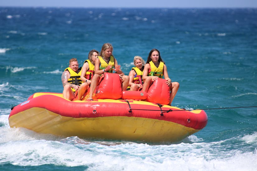 Una famiglia fa un giro su un gonfiabile sulla spiaggia di Ammourada con H2O Water Sports Heraklion.