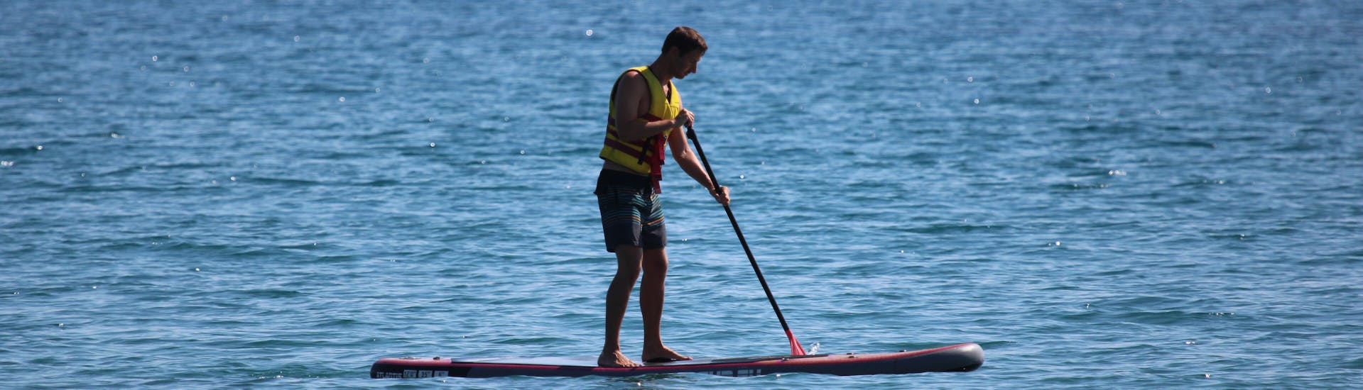 Man enjoying himself during his SUP Hire at Ammoudara Beach with H2O Water Sports Heraklion.
