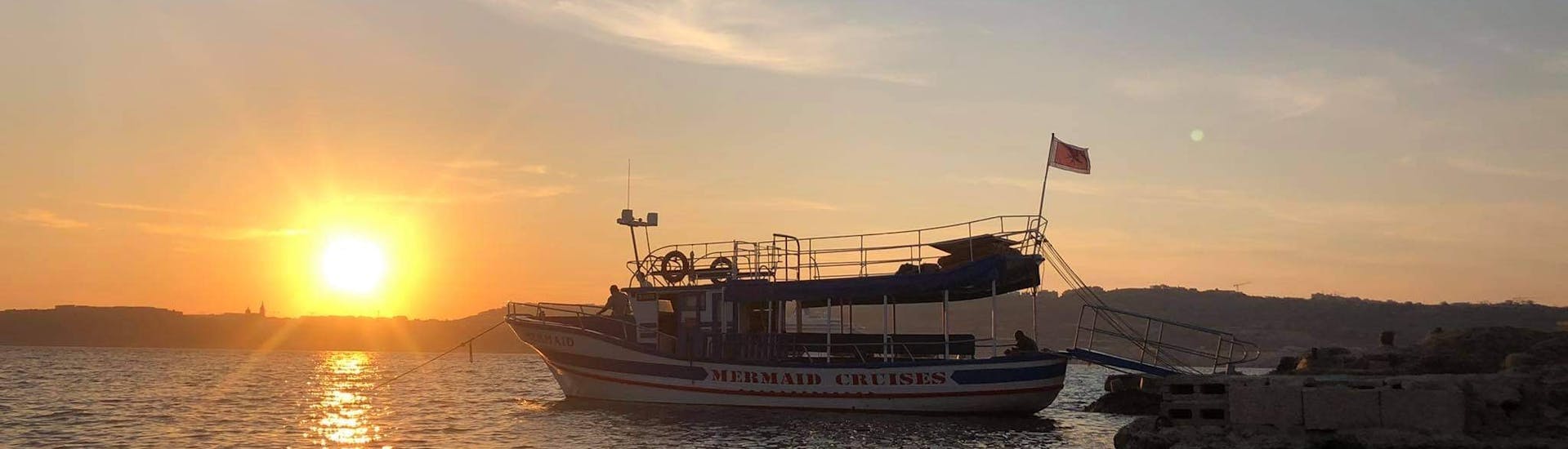 Nuestro barco sobre el agua en plena puesta de sol durante el crucero al atardecer a la Laguna Azul en Comino con Mermaid Cruises Malta.