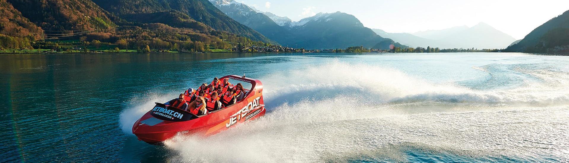 A group of people is enjoying a jet boat ride on Lake Brienz with Outdoor Interlaken.