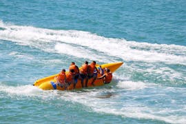 Eine Gruppe junger Leute genießt eine Fahrt mit dem Banana Boot am Stafilia Beach mit Sabina's Watersport Rhodos.