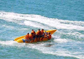 A group of young people is enjoying a banana boat ride on Stafilia Beach with Sabina's Watersport Rhodes.