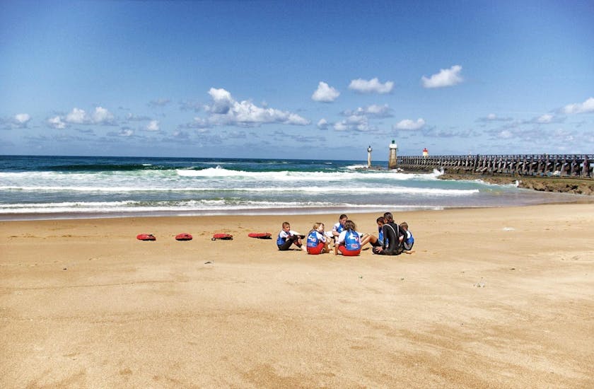 Kids are listening to their surfing instructor before their surfing lessons for kids with Capbreton Surfer School.