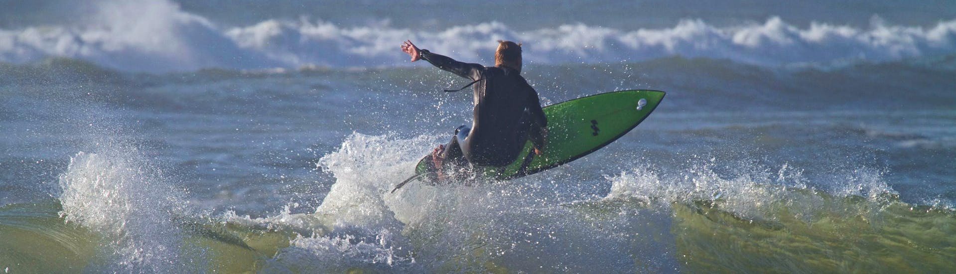 Un surfeur surfe sur une vague pendant son cours privé de surf avec Capbreton Surfer School.