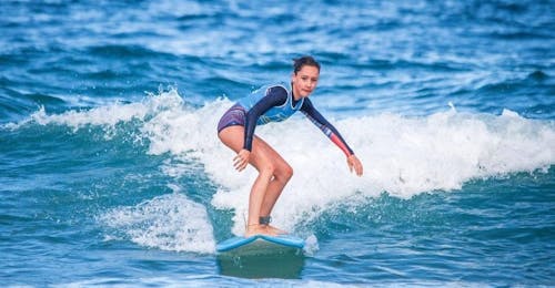 Clases privadas de surf (a partir de 6 años) en la Playa de La Savane Una chica surfea con confianza gracias a sus clases particulares de surf en la playa de La Savane, con Capbreton Surfer School.