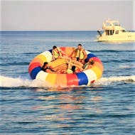 A group of friends is having fun on a towable tube ride in Kavos with Asprokavos Watersports.