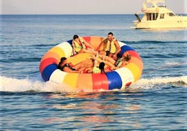 A group of friends is having fun on a towable tube ride in Kavos with Asprokavos Watersports.