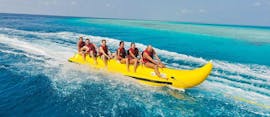 Eine Gruppe von Menschen hat Spaß bei einer Fahrt auf dem Banana Boat am Strand von Rethymno mit Popeye Watersports.