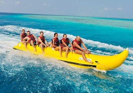 A group of people have fun in a Banana Boat ride on Rethymno Beach with Popeye Watersports.