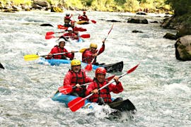 An adventurous group is paddling across the rapids in their the canoe-raft on the river Stura di Demonte with KE Rafting Roccasparvera.