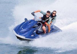 Un uomo e una donna sfrecciano sull'acqua su una moto d'acqua noleggiata da Adventure Croatia.