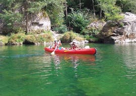 Two friends are gently paddling and enjoying the landscapes during their Canoe Rental on the Tarn River - Discovery 7km tour with Canoë Aigue Vive Gorges du Tarn.
