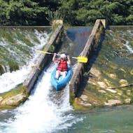 Ein Kajakfahrer rutscht während des Kanuverleihs auf dem Fluss Tarn eine natürliche Wasserrutsche hinunter - Emotion 11 km Tour mit Canoë Aigue Vive Gorges du Tarn.