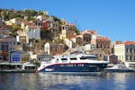 Das Boot von Manos Going Rhodos legt während der Bootstour zur Insel Symi mit Symi Stadt & Kloster Panormitis in Symi-Stadt an.