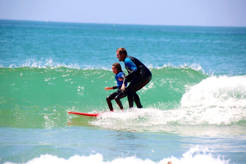 Un surfeur surfe sa première vague pendant son Cours de surf Enfants (7-14ans) sur la plage de la Madrague avec Anglet Surf Spirit.