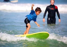A young boy is learning to surf during his Surfing Lessons for Kids (7-14 y.) on Madrague Beach with Anglet Surf Spirit.