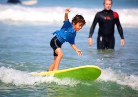 A young boy is learning to surf during his Surfing Lessons for Kids (8-14 y.) on Madrague Beach with Anglet Surf Spirit.