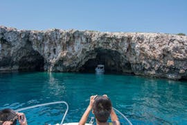 Ein junger Mann macht während der privaten Bootstour nach Hvar inkl. Blauer Höhle ab Trogir mit Mayer Charter Trogir Fotos von der Höhle.