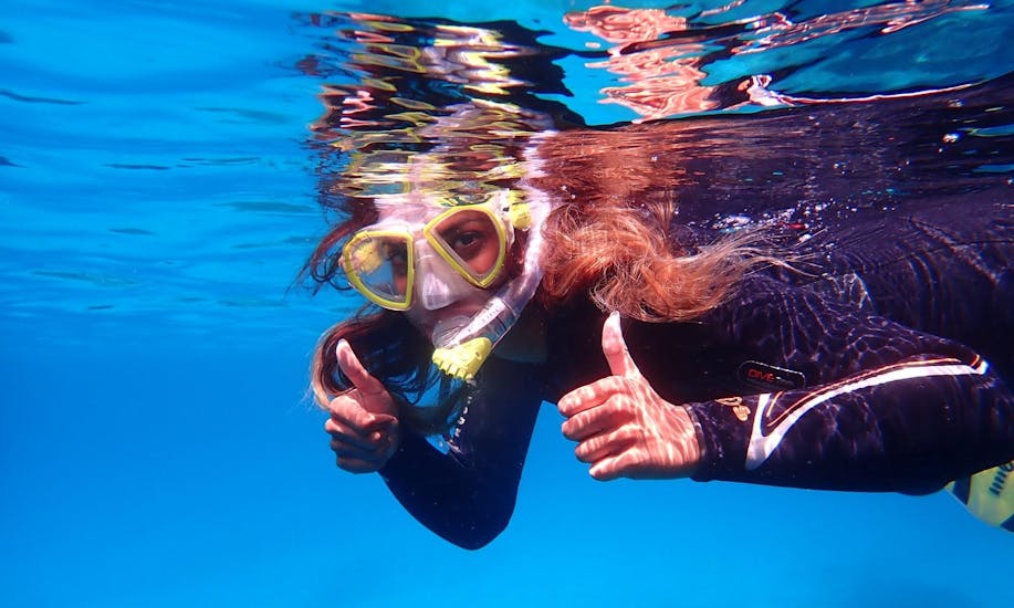 Während der Schnorcheltour zum Naturschutzgebiet Cala Delta mit Diving and Adventure Mallorca schnorchelt eine junge Frau im kristallklaren Wasser.