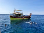 Un grupo de personas disfruta de un baño en el mar durante el Paseo en barco privado al cabo Kamejak desde Medulin con Medulin Excursions.