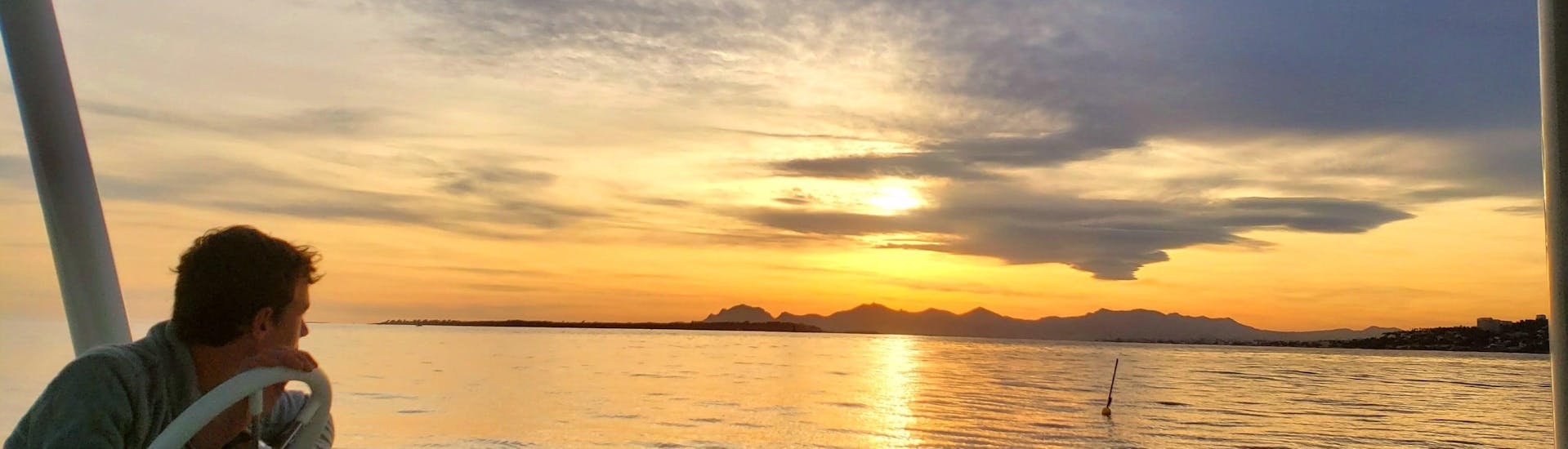 Ein Mann beobachtet den Sonnenuntergang während einer Privaten Katamarantour in der Bucht von Juan-les-Pins bei Sonnenuntergang mit SeaZen.