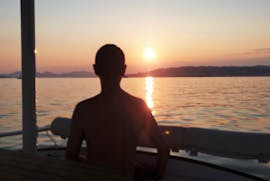 Un homme regarde le coucher de soleil lors d'une balade privée en catamaran dans la baie de Juan-les-Pins avec SeaZen.