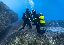 Ein Tauchlehrer gibt einem Taucher während eines SSI Scuba Diver Kurses in Cap d'Antibes für Anfänger mit BeFree2Dive Ratschläge.