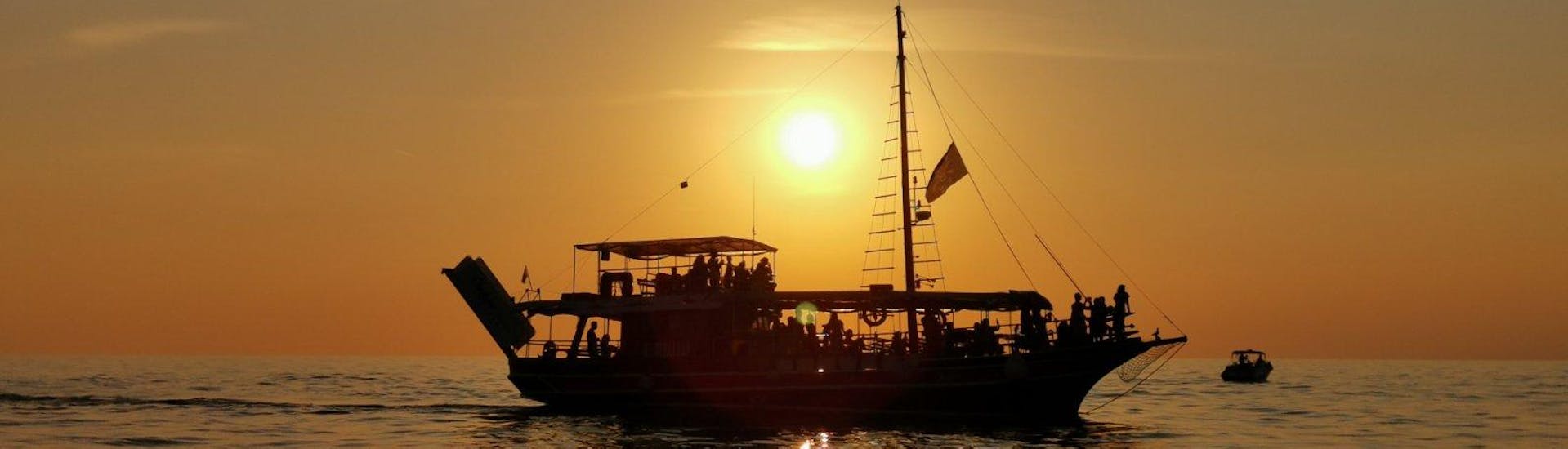 De lucht kleurt oranje tijdens de boottocht bij zonsondergang rond Poreč met dolfijnen spotten Kristofor georganiseerd door Boat Excursions Poreč.