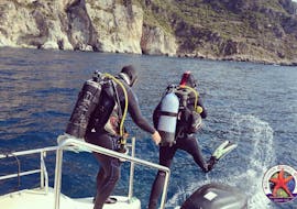 Dos buceadores están saltando en el agua durante el curso PADI Open Water Diver en Paleokastritsa para principiantes con Achilleon Diving Center Corfú.