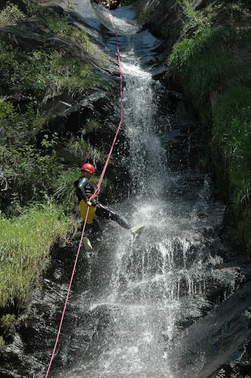 A woman descends barranco de Estaron during a canyoning activity with Rafting Llavorsí.