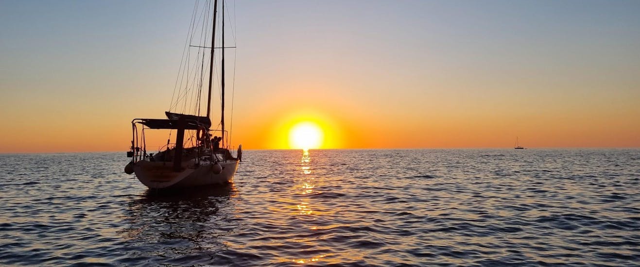 A private sailing yacht navigates at sunset in Mallorca with Let's Sail Mallorca.