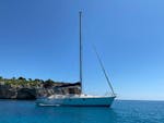 A sailing boat navigates around the east coast of Mallorca with Let's Sail Mallorca.