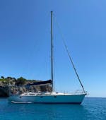 A sailing boat navigates around the east coast of Mallorca with Let's Sail Mallorca.