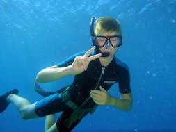 Een kind gaat snorkelen in de baai van Agios Nikolaos met Pelagos Dive Center op Kreta.