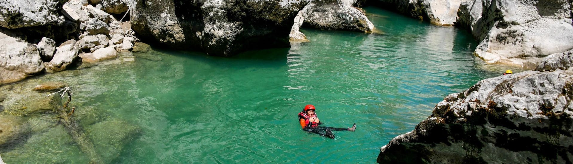 A woman is floating in the river during her River Trekking Tour in Pont de Tusset in Verdon for Families with Feel Rafting.