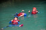 Ein paar Kinder lassen sich bei ihrer Flusstrekking Tour am Pont de Tusset im Verdon für Familien mit Feel Rafting treiben.