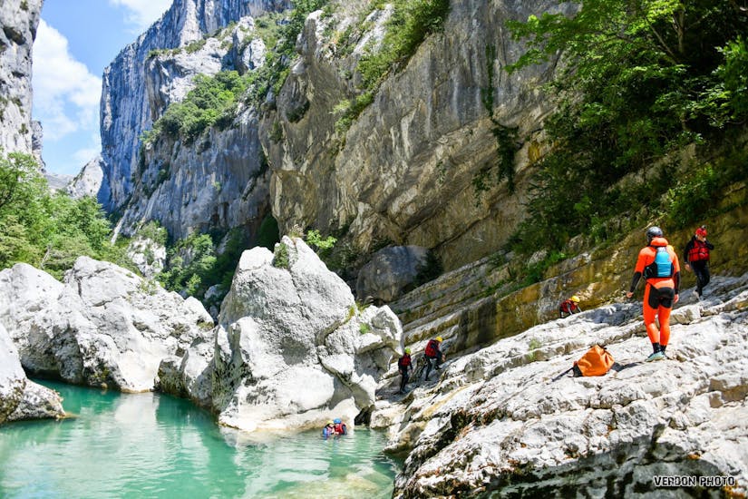 Friends are walking along the impressive cliffs of the Verdon gorges during their River Trekking Tour in Couloir Samson in Verdon with Feel Rafting.