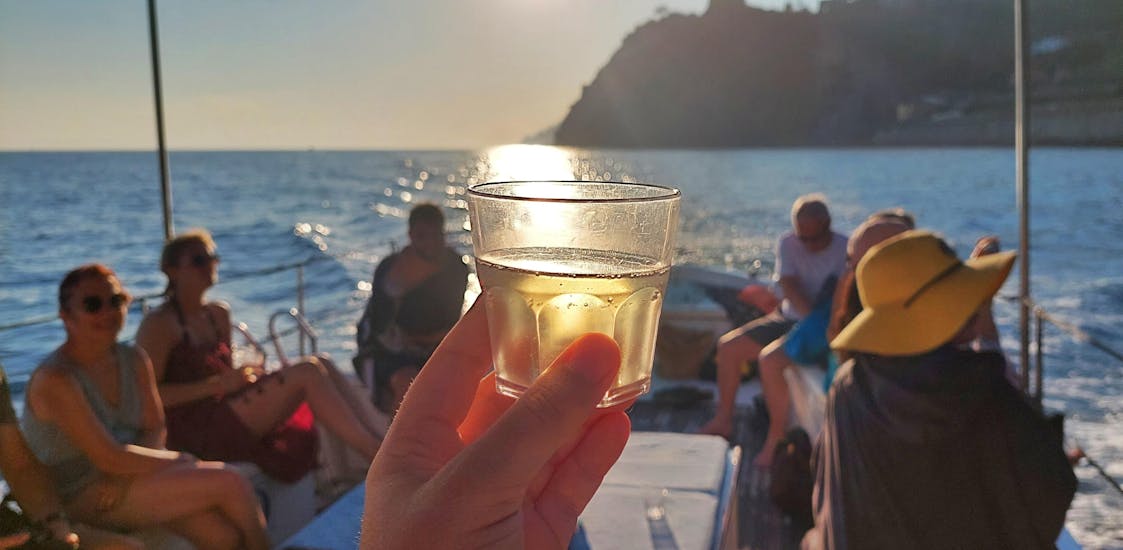 During the Sunset boat trip in Cinque Terre from Monterosso and Levanto with Ale 5 Terre participants drink prosecco while watching the sunset.